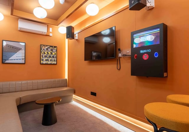 Lounge seating with TV and interactive screen common area at iQ Paris Gardens in London Student Accommodation