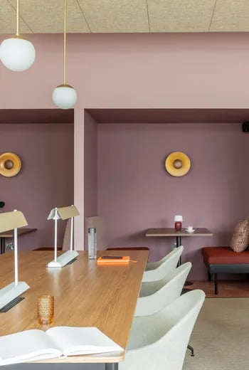 Long wooden table lamps chairs and books study area at ARK Wembley in London Student Accommodation
