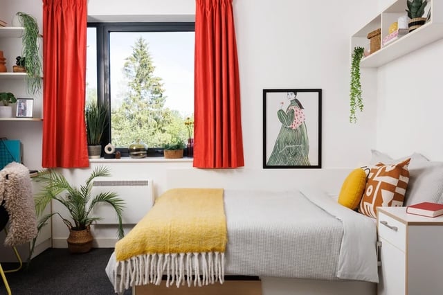 Bed with yellow throw and pillows bedroom at Elvet Studios in Durham Student Accommodation