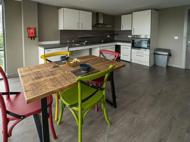 Wooden dining table four colorful chairs kitchen kitchen at Scotway House in Glasgow Student Accommodation