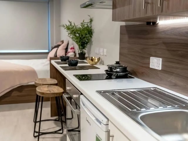 Kitchenette with bed and two stools kitchen Image at Scotway House in Glasgow Student Accommodation