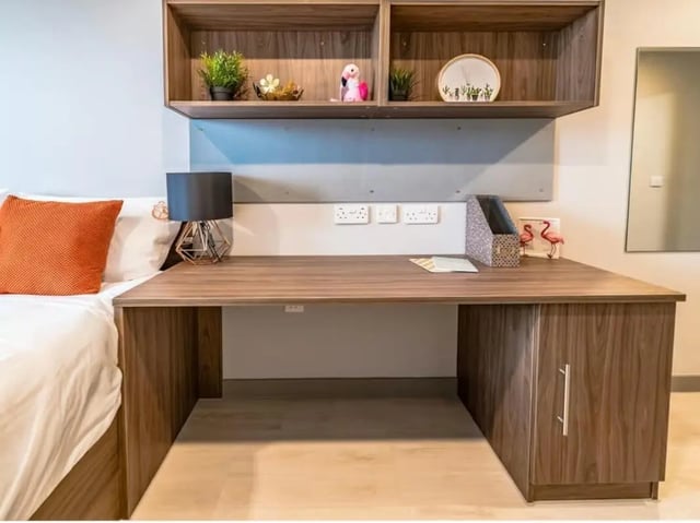 Bed desk lamp shelves and flamingo decoration study room at Scotway House in Glasgow Student Accommodation