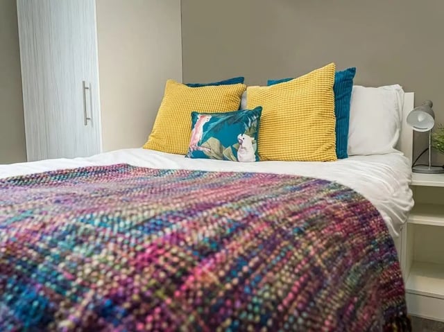 Bed with colorful throw yellow cushions bedroom at Scotway House in Glasgow Student Accommodation