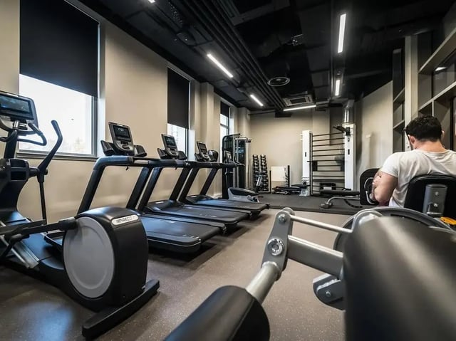 Cardio machines weight racks and person gym at Scotway House in Glasgow Student Accommodation