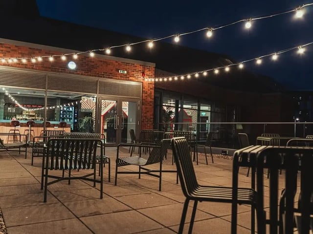 Outdoor seating area with cafe and string lights exterior at Scotway House in Glasgow Student Accommodation