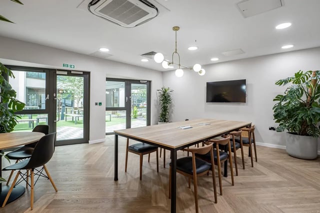 Dining table with chairs near glass doors Common area at Chapter Old Street in London Student Accommodation