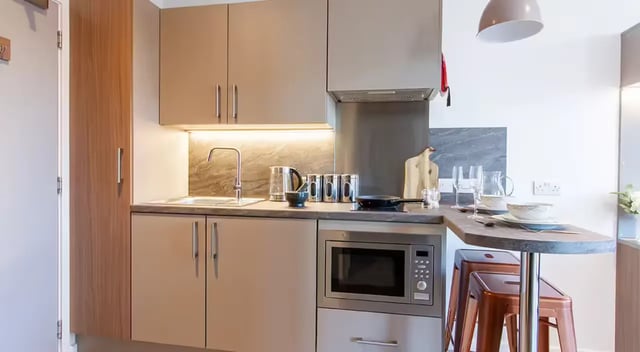 Modern kitchen counter with microwave and stools kitchen at Dean Street Works in Bristol Student Accommodation