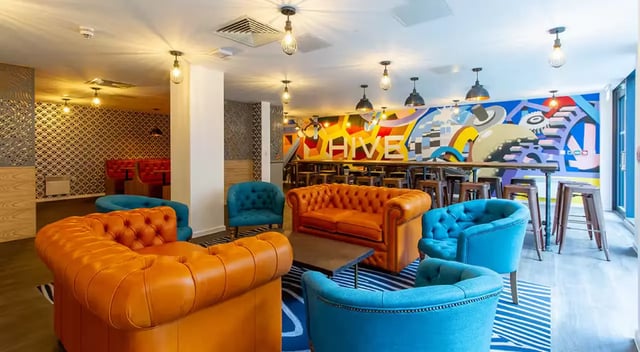 Sofas chairs table mural and bar stools common area at Dean Street Works in Bristol Student Accommodation