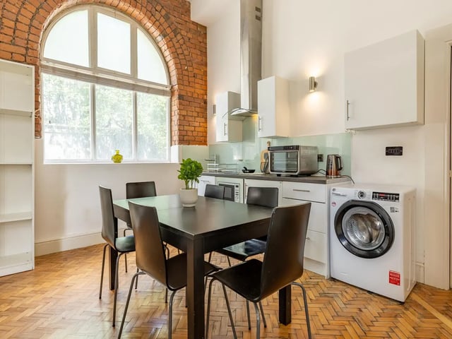 Dining table chairs washing machine kitchen interior. at Ashton House in Manchester Student Accommodation