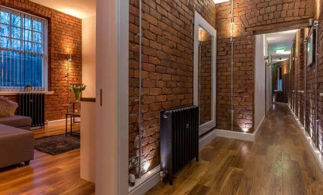 Brick wall hallway with wood floor and lighting Interior at Ashton House in Manchester Student Accommodation