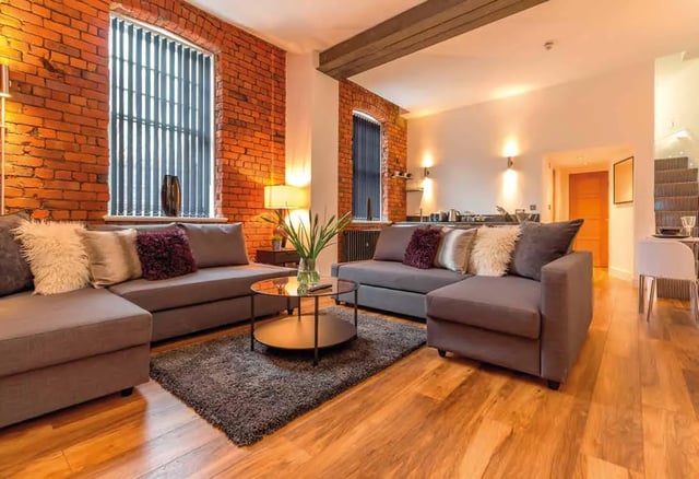 Grey sectional sofa coffee table plush rug living room at Ashton House in Manchester Student Accommodation
