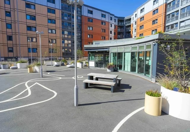 Picnic bench with planters and modern building exterior area at iQ Kerria Apartments in Manchester Student Accommodation