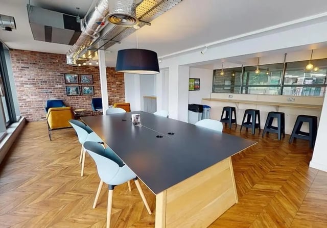 Long table with chairs and stools communal area at iQ Wilmslow Park in Manchester Student Accommodation