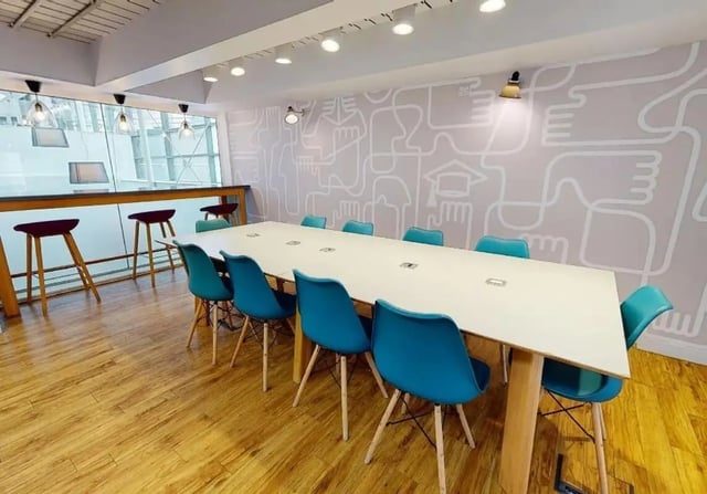 Long table with blue chairs communal area at iQ Wilmslow Park in Manchester Student Accommodation