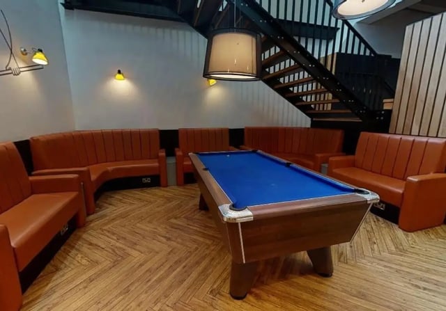 Pool table and orange seating area common room at iQ Wilmslow Park in Manchester Student Accommodation
