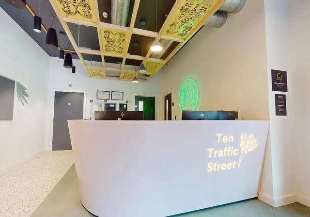 Reception desk with monitors and neon sign reception at iQ Signal Place in Nottingham Student Accommodation