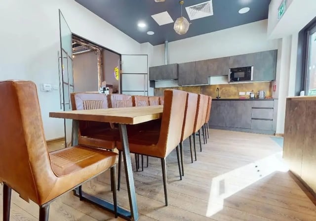 Long wooden table with brown chairs kitchen area at iQ Signal Place in Nottingham Student Accommodation