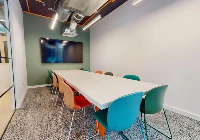 Conference table with colorful chairs and screen meeting room at iQ Signal Place in Nottingham Student Accommodation