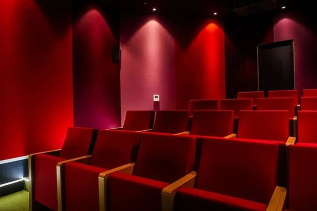 Red cinema seating with wooden armrests and projector cinema at Chapter Highbury in London Student Accommodation