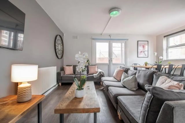 Grey sofas wooden table lamp and plants living room at 28 Church Street in Nottingham Student Accommodation