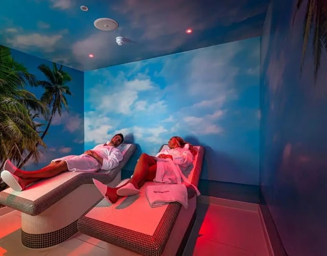 Two people relax on chaise lounges in a spa area. at Triumph House in Nottingham Student Accommodation