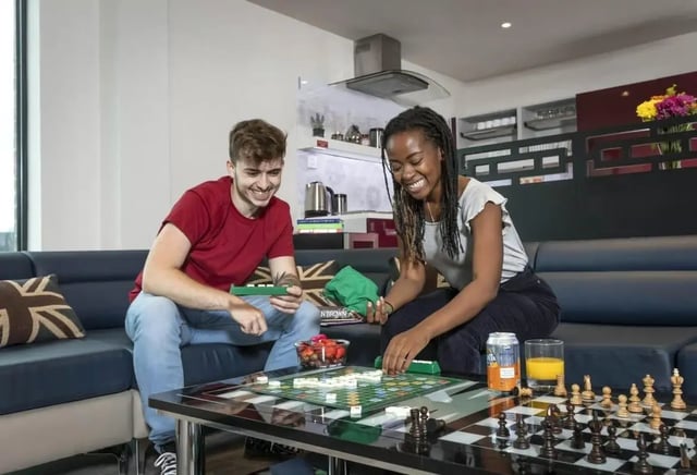 Two students playing games on sofa living room at Triumph House in Nottingham Student Accommodation