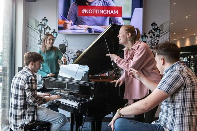 Students playing grand piano in communal area at Triumph House in Nottingham Student Accommodation