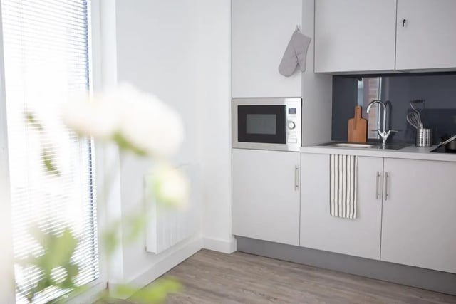 Microwave oven oven mitt sink and cabinets kitchen at The Laceworks Nottingham in Nottingham Student Accommodation