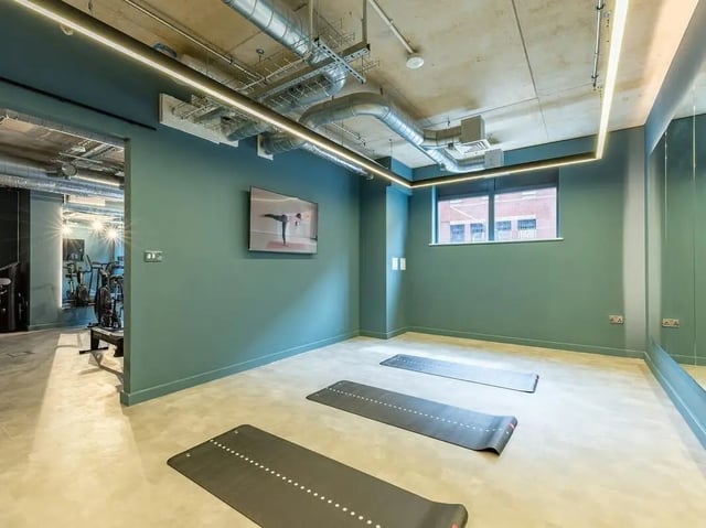 Yoga mats and fitness equipment visible gym area at Fabric in Nottingham Student Accommodation