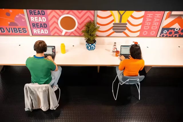 Students working at long desk with artwork study area at Scape Adelaide Central in Adelaide Student Accommodation