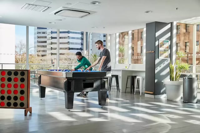Two men playing billiards in a common area. at Scape Adelaide Central in Adelaide Student Accommodation
