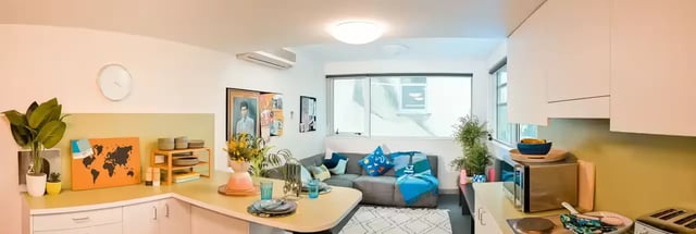 Sofa with colorful cushions and kitchen counter living room at Scape Adelaide Central in Adelaide Student Accommodation