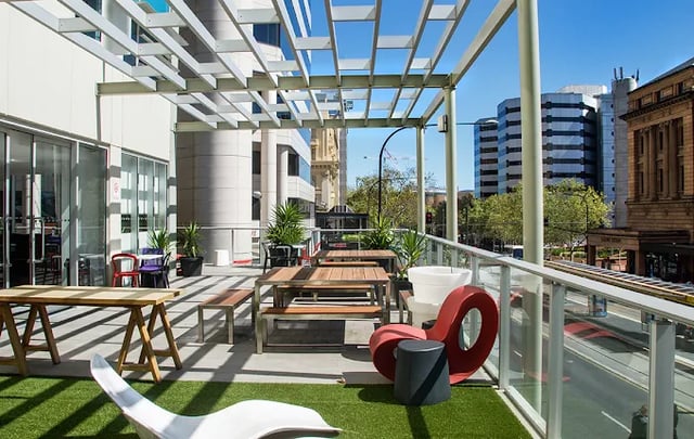 Outdoor seating tables benches chairs with city view exterior at Scape Adelaide Central in Adelaide Student Accommodation