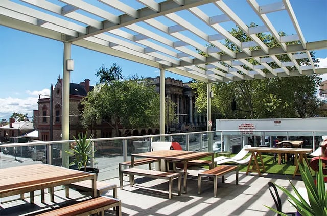 Tables benches and loungers on rooftop area at Scape Adelaide Central in Adelaide Student Accommodation