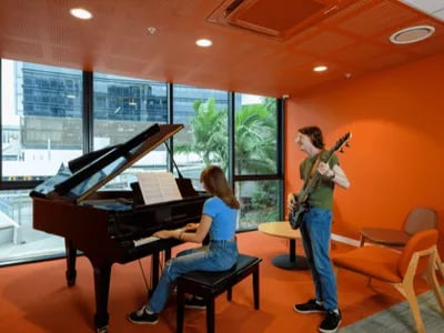 Woman plays piano man plays guitar lounge at Unilodge South Bank in Brisbane Student Accommodation