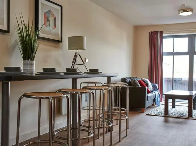 Bar stools table plant and sofa living area at Abbeygate in Chester Student Accommodation