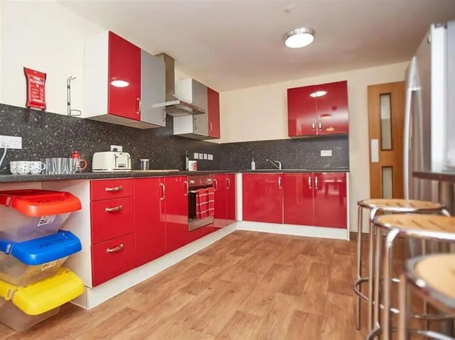 Red cabinets toaster fire blanket and bins kitchen at Abbeygate in Chester Student Accommodation