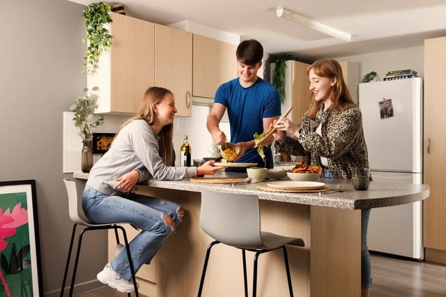 Students prepare food at kitchen island kitchen at Grand Central in Liverpool Student Accommodation