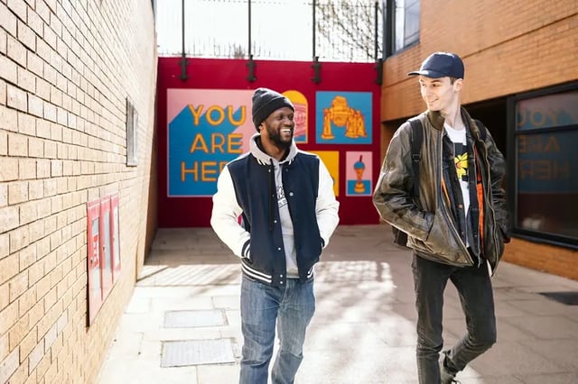Two students walk past artwork exterior at The Pinnacles in Sheffield Student Accommodation