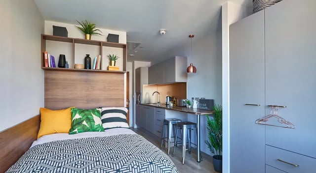 Bed kitchen cabinets shelves study area studio apartment at Cumberland Place in Southampton Student Accommodation