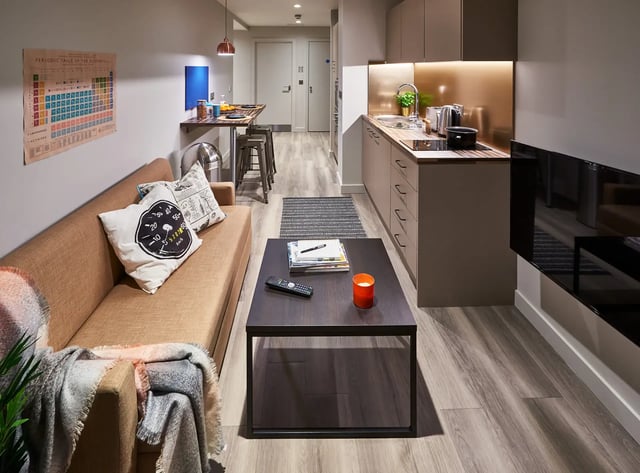 Sofa coffee table kitchen cabinets and stools Living room at Cumberland Place in Southampton Student Accommodation