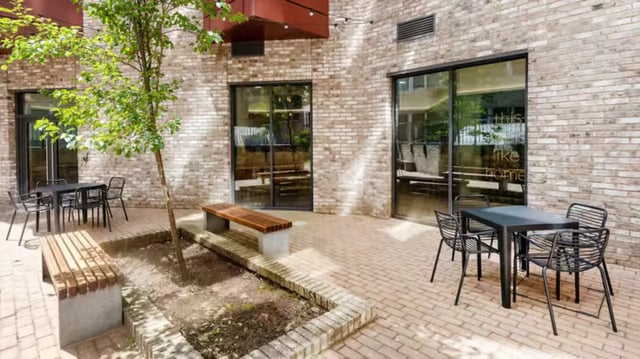 Tables chairs benches and a tree courtyard exterior at Fontenoy Apartments in Liverpool Student Accommodation