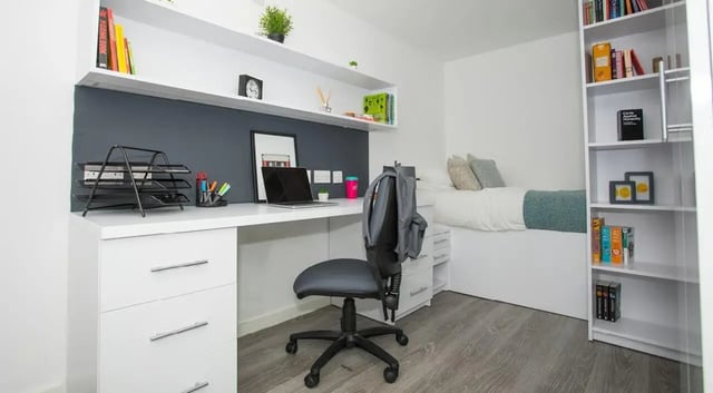 Desk with laptop chair bed and bookshelf student room at The Cube Ealing in London Student Accommodation