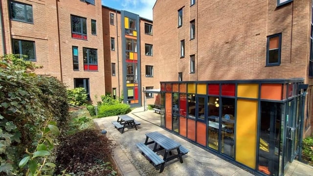 Picnic tables outside modern brick building exterior at The Village at The Viaduct in Durham Student Accommodation