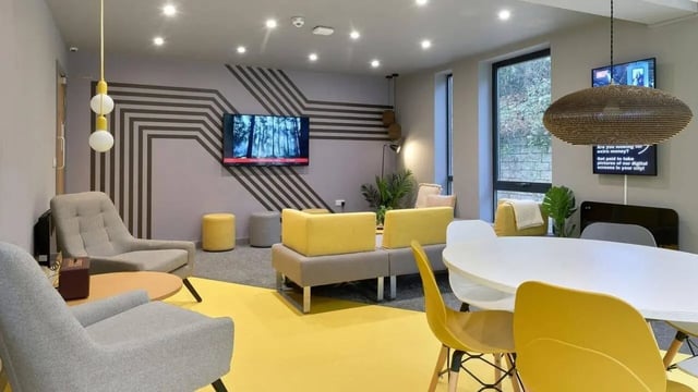 Modern communal area with sofas tables and chairs living room at The Village at The Viaduct in Durham Student Accommodation