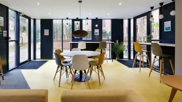 Round dining table with chairs and bar stools communal area at The Village at The Viaduct in Durham Student Accommodation