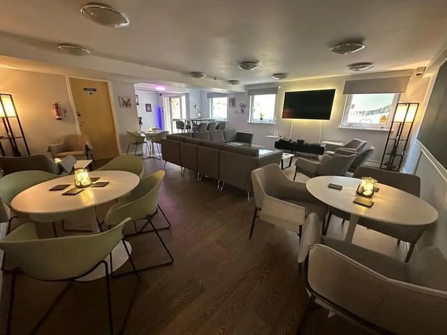 Seating area with tables couches and television lounge at College Court in Stoke-On-Trent Student Accommodation