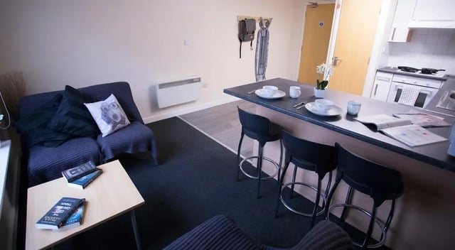 Sofa kitchen counter with stools living room kitchen at College Court in Stoke-On-Trent Student Accommodation