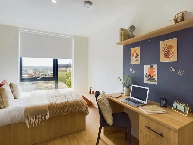 Bed desk laptop plants artwork calendar bedroom at Straits Aire in Leeds Student Accommodation