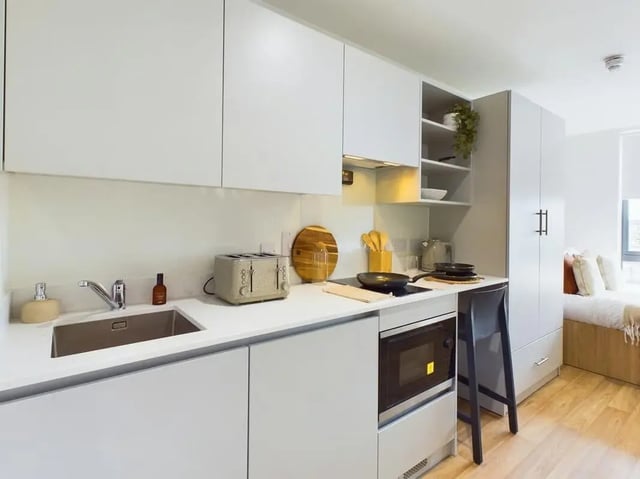 Modern kitchen with sink toaster microwave and bed area kitchen at Straits Aire in Leeds Student Accommodation